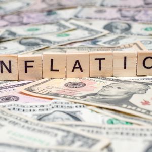 The word inflation on a pile of  money.